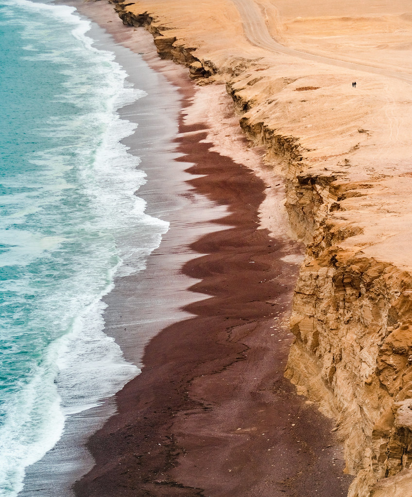 Rust-colored beach and cliffs in Paracas National Reserve
