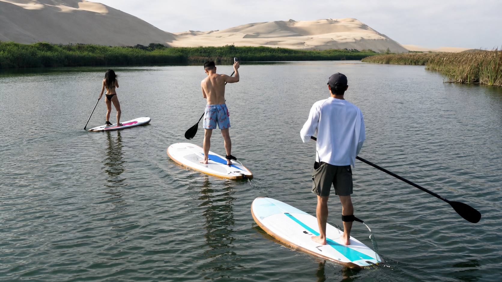 Travelers paddleboarding on a private desert lagoon near Paracas